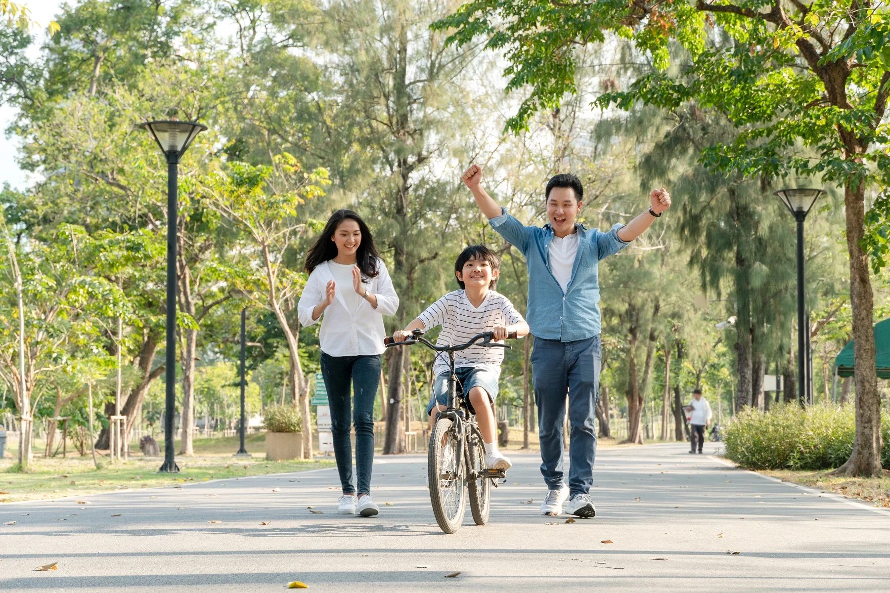 הורים מעודדים את בנם לרכוב על אופניים