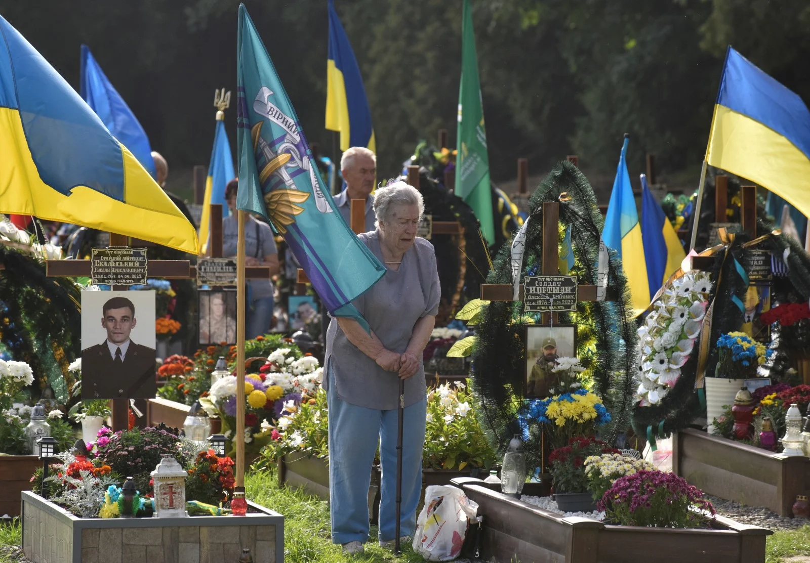 אישה מבוגרת פוקדת את קברו של קרוב משפחה שלה שנהרג במלחמה באוקראינה בעיר לביב