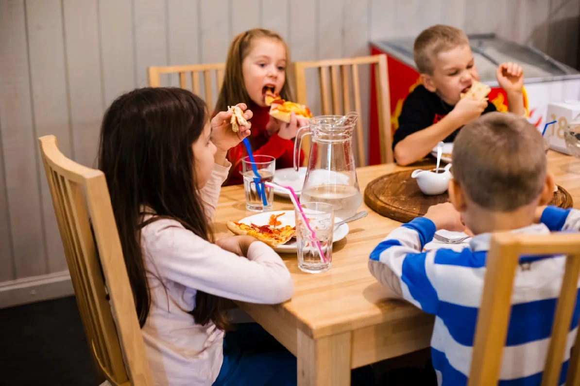 ילדים אוכלים סביב השולחן