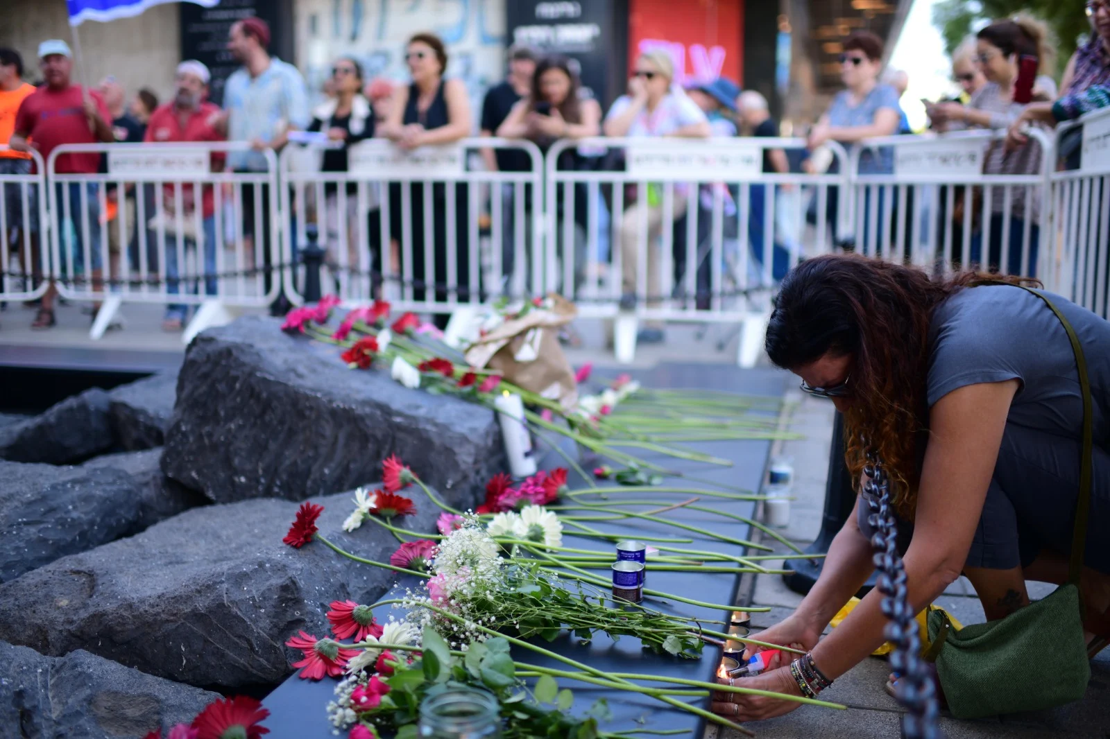 אנשים מניחים פרחים על האנדרטה לזכר יצחק רבין בכיכר
