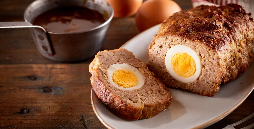 Meatloaf,baked,with,egg,inside,sliced,on,white,dish,on