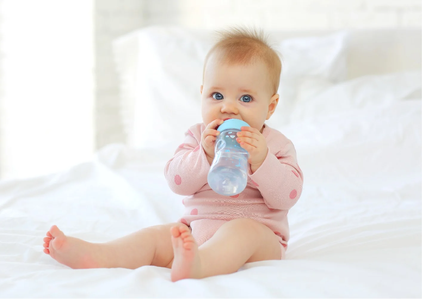 תינוק שותה מים במיטה
