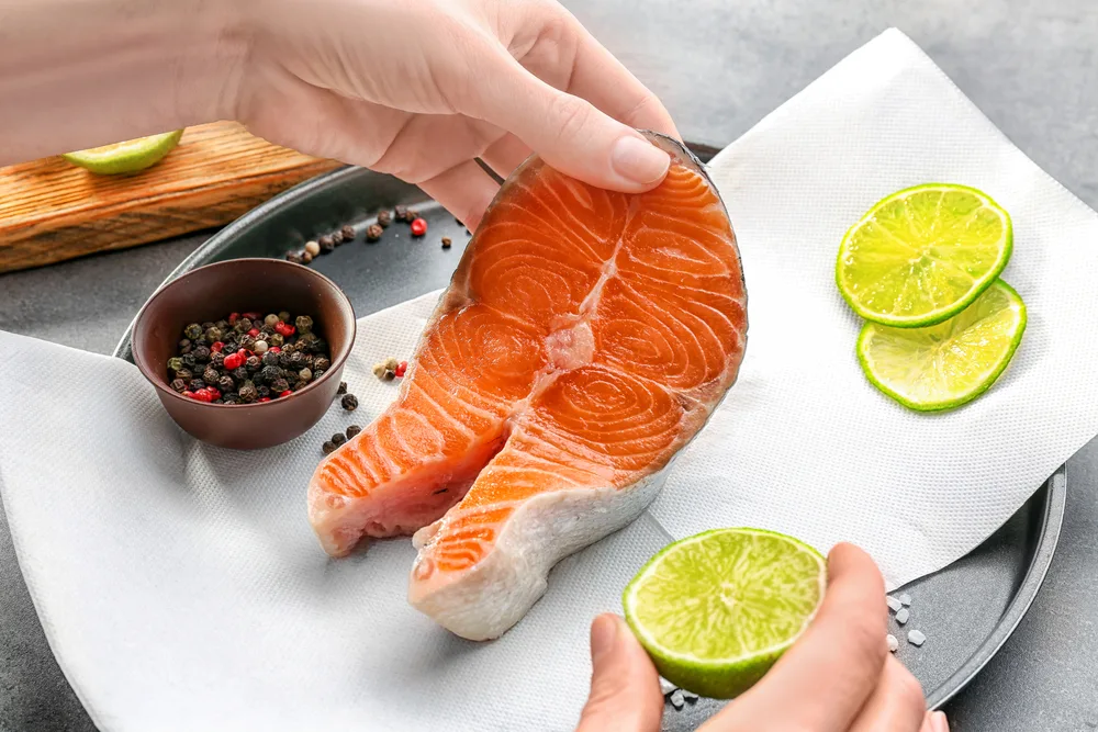 Woman,marinating,salmon,steak,,closeup