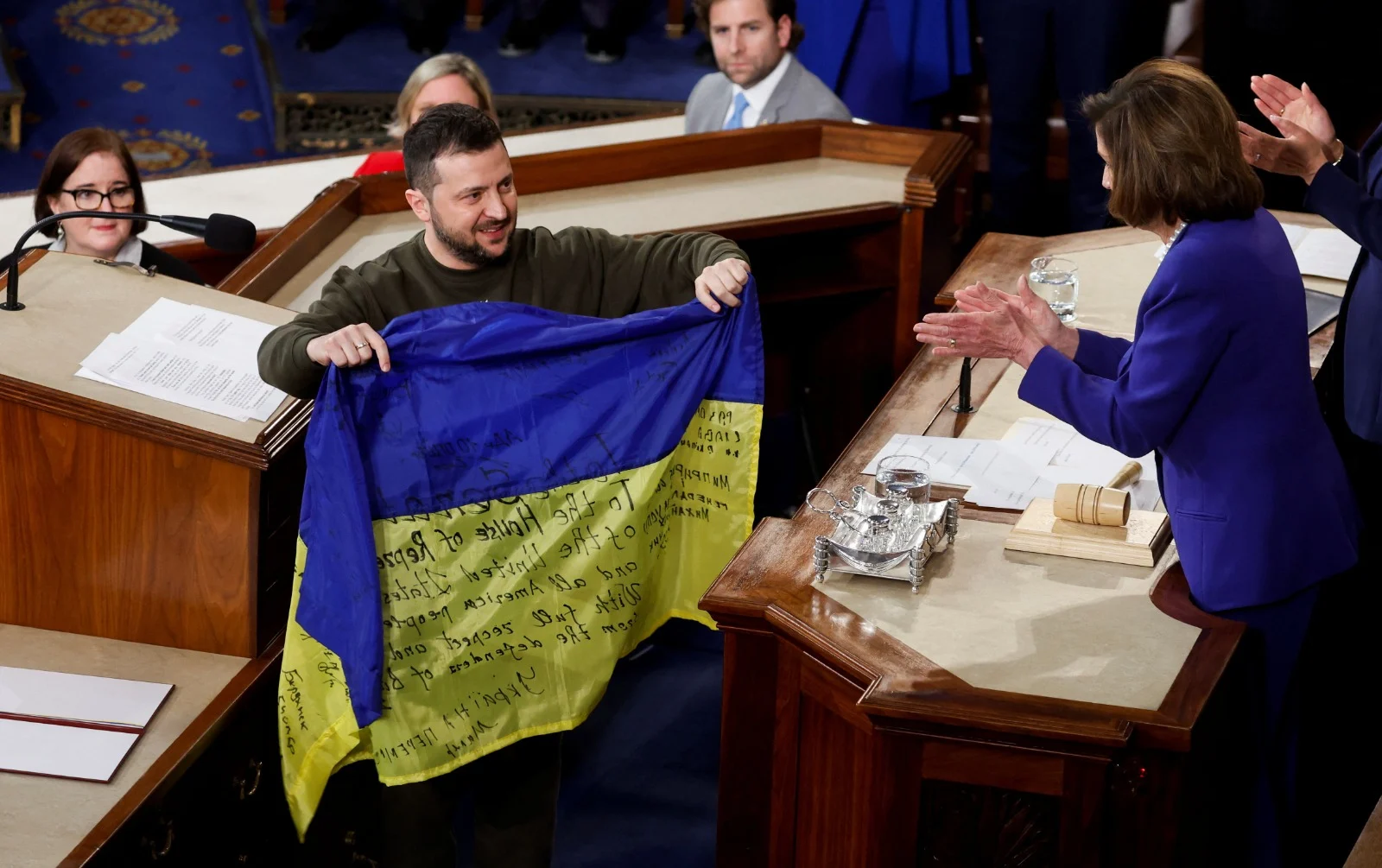 זלנסקי מביא ליו''ר בית הנבחרים פלוסי את דגל אוקראינה שקיבל מהחיילים המגינים על העיר בחמוט