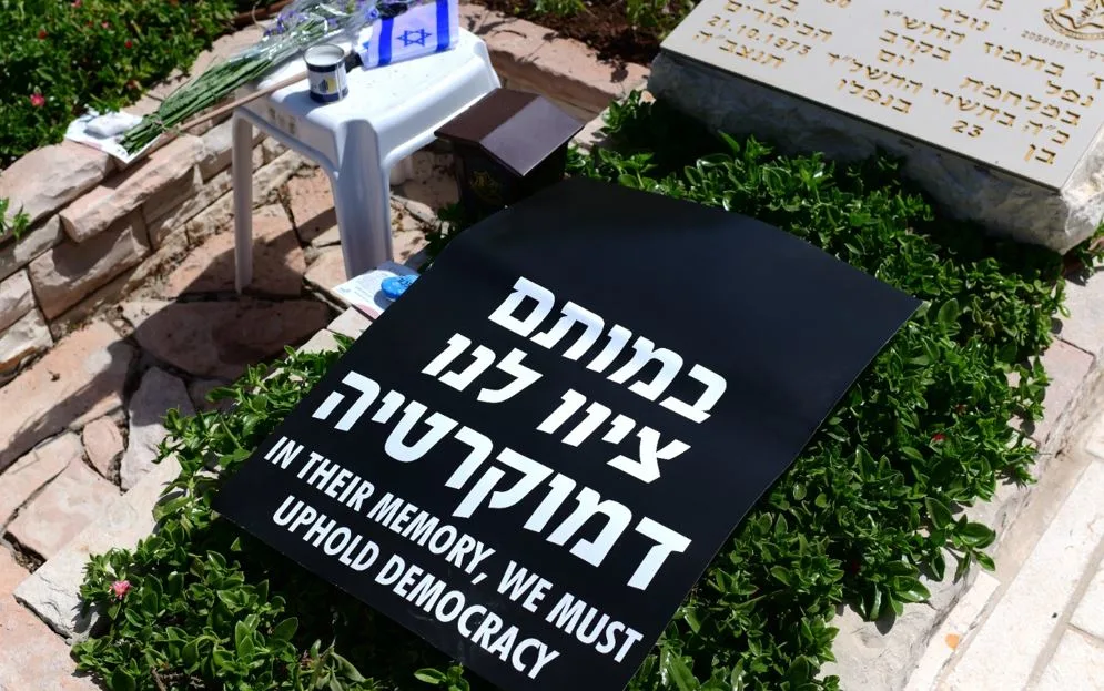 כרזת ''במותם ציוו לנו דמוקרטיה'' על קבר בבית העלמין בקריית שאול