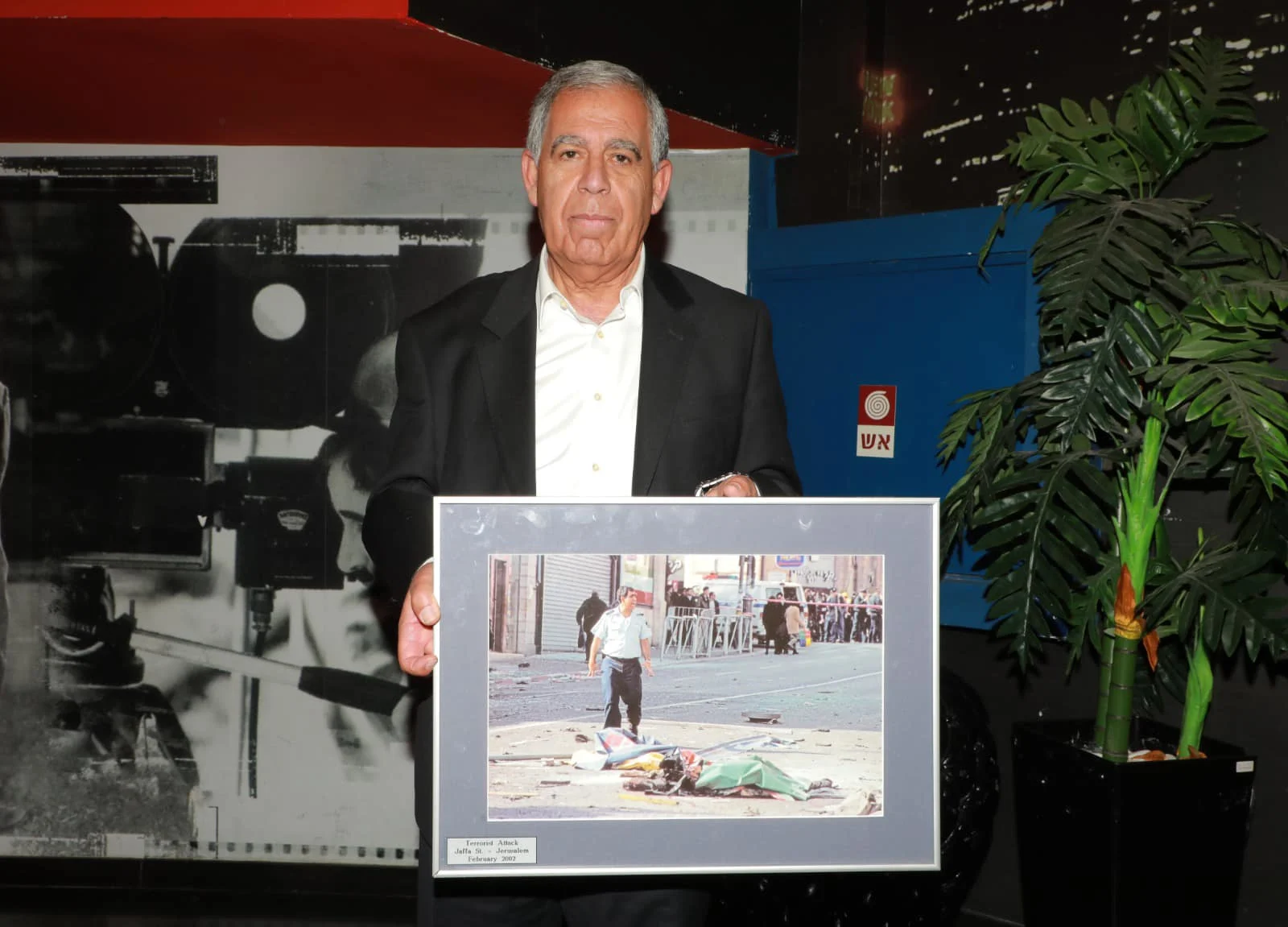 מיקי לוי עם התמונה שלו מזירת הפיגוע בירושלים